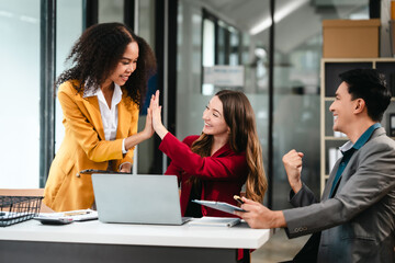 Diverse group of three professionals, two women and man, working together on design project around laptop. Product design team for industrial, working together, Asian man, African american people