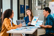© Phushutter - diverse team of professionals engaged in a website graphic design board meeting, sharing opinions on UX and UI design elements. Asian man, African American people, black, afro, caucasian female