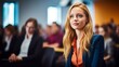 © Nick - a woman sitting in front of a group of people in a business conference