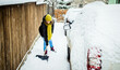 woman with shovel cleaning snow. Winter shoveling. Removing snow after blizzard