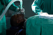 © Wavebreak Media - Diverse surgeons wearing surgical gowns using anaesthetic mask in operating theatre at hospital
