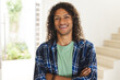 © Wavebreak Media - Happy biracial man with long dark curly hair laughing in sunny living room at home