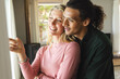 © Wavebreak Media - Happy diverse couple embracing and discussing in sunny living room