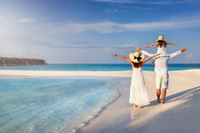 A Happy Family Walks Down A Tropical Beach As A Concept For A Beach Holiday