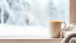 © Anna Studio - Winter holidays, calm and cosy home, cup of tea or coffee mug and knitted blanket near window in the English countryside cottage, holiday atmosphere