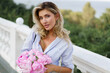 © Svetlana Sokolova - Portrait   of elegant beautiful cheerful  blond woman in   stylish casual outfit  , holding  pink boquet with pions flowers.