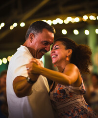 A happy Cuban couple dances traditional salsa at a night celebration