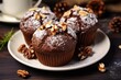 © Lubos Chlubny - Cocoa muffins covered with chocolate and sprinkled with walnuts on a white plate