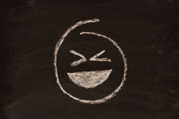 Wall Mural - Emoticon, imoji drawn melo on dark background, laughing.