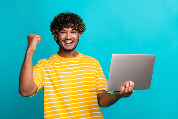 Poster - Photo of delighted funky guy hold wireless netbook raise fist success achievement isolated on teal color background