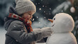 Cute little boy making a snowman outside in winter