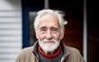© Bonsales - Wrinkled face of ordinary kindly senior man with grey hair and beard wearing in casual clothing standing outdoor and looking at camera
