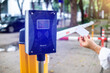 Selective focus to RFID card in hand of driver with blurry RFID reader for automatic barrier gate system. Parking and automatic payment system with licence plate recognition.