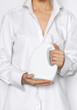 Liquid detergent bottle in woman hands wearing white man's shirt