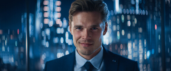 Poster - Close Up Portrait of Handsome Caucasian Businessman in Stylish Suit Posing Next to Window in Big City Office with Skyscrapers Late At Night. Male CEO Smiling And Looking At Camera.
