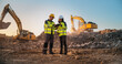 © Gorodenkoff - Caucasian Male Civil Engineer Talking To Hispanic Female Inspector And Using Tablet On Construction Site of New Apartment Complex. Real Estate Developers Discussing Business, Excavators Working.