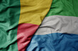 big waving national colorful flag of benin and national flag of sierra leone .