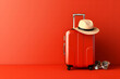 red colorful travel bag with straw hat and sunglasses isolated on red.