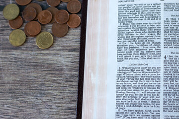 Wall Mural - Open bible book prophet Malachi 3 verses for Christian tithing and offering to God Jesus Christ and coin money on wooden table. Top view. Biblical concepts of giving tithes, obedience, and generosity.