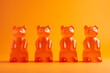 Orange flavored immune gummy bears for children are lined up on an orange background. Dietary supplement