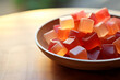 Apple cider vinegar gummies in a transparent plate on a wooden table