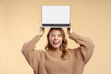 happy student winks, holding laptop on head showing computer screen, learning language, mockup. smil