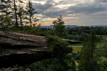 Wall Mural - trees, grass, mountains and clouds near a rocky cliff