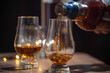 © barmalini - Glasses of single malt and blended scotch whisky served in bar in Edinburgh, Scotland, UK with party lights on background
