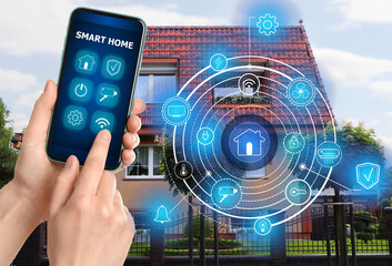 Canvas Print - Woman using smart home control system via application on mobile phone outdoors, closeup. Scheme on house