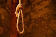 Noose in prison of old castle cellar and grunge stone wall close up
