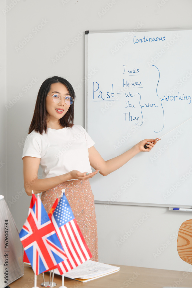 Female English teacher conducting grammar lesson in classroom