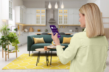 Canvas Print - Woman using smart home control system via application on mobile phone indoors