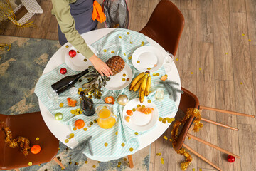 Poster - Female janitor cleaning table in messy living room after New Year party, top view