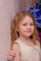 Wall Mural -  A beautiful elegant girl near the Christmas tree in the New Year. Holiday. New Year. The child is a model.