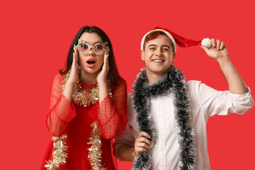 Sticker - Young couple with Christmas tinsel on red background