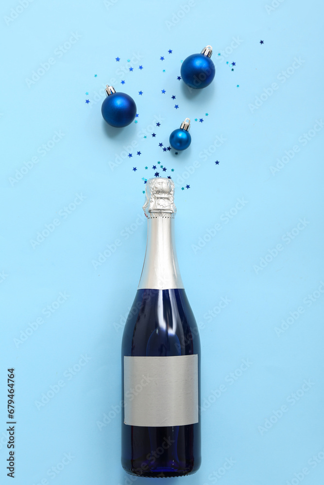 Champagne bottle with Christmas decor on blue background