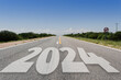 Año nuevo 2024 o concepto de inicio.. Palabra 2024 escrita en la carretera asfaltada en día radiante. Concepto de desafío y cambio.