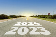 Año viejo 2023 y año nuevo 2024 o concepto de fin e inicio. 2023 y 2024 escritos en el camino en día radiante. Concepto de desafío, cambios y logros.