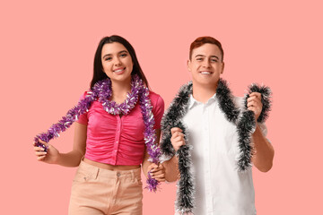 Sticker - Young couple with Christmas tinsel on pink background