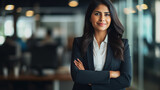 Fototapeta  - Young confident smiling Indian business woman leader, successful entrepreneur, professional company executive ceo manager, wearing suit standing in office with arms crossed. made with generative ai