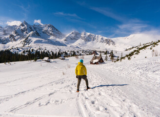 hiker looking at a snowy mountain landscape in a sunny winter day. european hiking solo outdoor acti