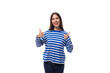 young groovy cheerful caucasian woman with dark hair dressed in a blue striped sweatshirt on a white background