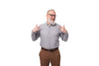 60 year old elderly business man with a mustache and a gray beard is dressed in a shirt and trousers
