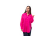 pretty young brunette lady dressed in a bright pink shirt points with her hands in a row of advertising