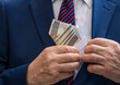 Człowiek w eleganckim garniturze chowa kopertę z pieniędzmi do kieszeni w marynarce 