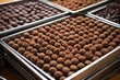 stacked steel trays filled with chocolate truffle bases