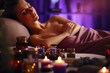 © pilipphoto - Young woman relaxing and enjoying in spa with candles, massage and aromatherapy