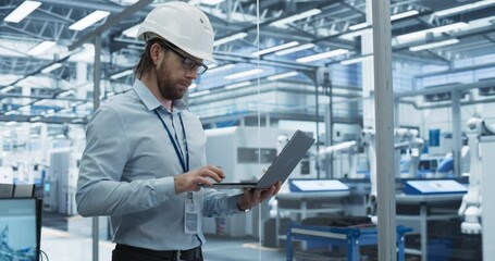 Fototapete - Chief Technology Officer Working on Laptop at a Conveyor at a Factory with Autonomous Robotic Arms. Industrial Engineer in a White Protective Hard Hat Working on the Assembly Line