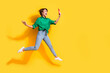© deagreez - Full length photo of shiny excited girl dressed green shirt jumping talking selfie modern device empty space isolated yellow color background