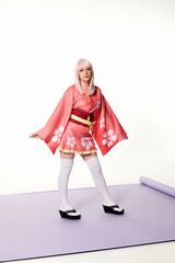 Wall Mural - japanese cosplay subculture, blonde woman in kimono and wig on purple carper and white backdrop